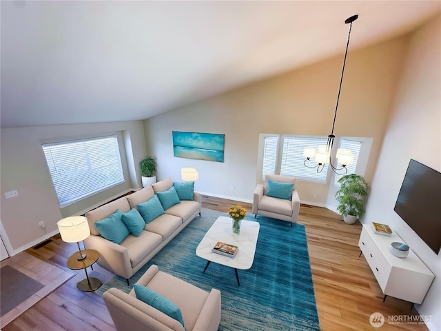 living room featuring a chandelier, baseboards, wood finished floors, and high vaulted ceiling