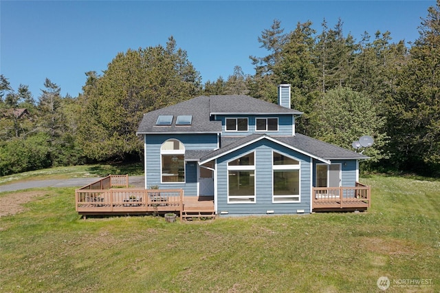back of house with a yard, a chimney, a deck, and roof with shingles