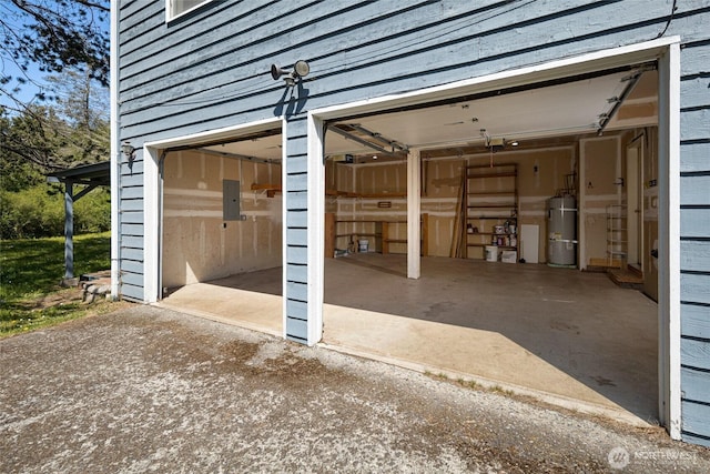 garage featuring secured water heater, electric panel, and driveway