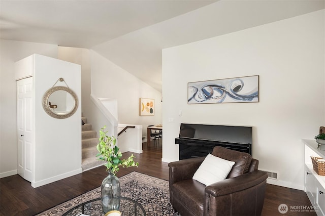 living room with stairs, baseboards, wood finished floors, lofted ceiling, and visible vents