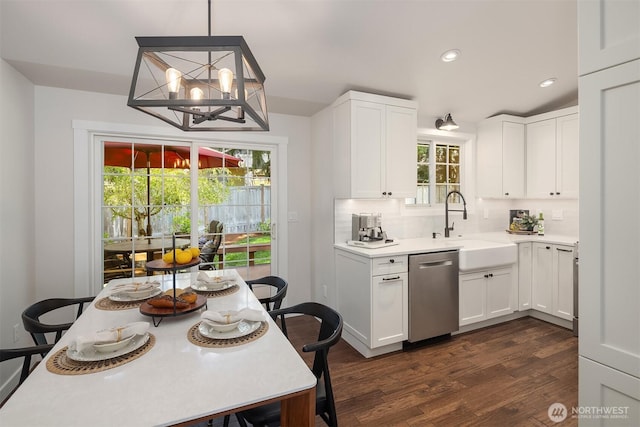 kitchen featuring stainless steel dishwasher, dark wood-type flooring, light countertops, white cabinetry, and a sink