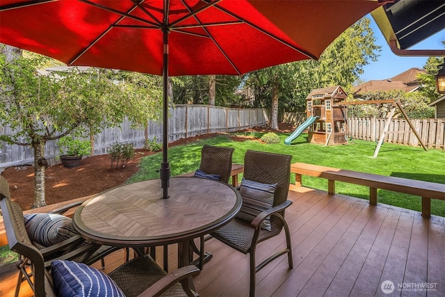 wooden deck with a fenced backyard, a playground, a yard, and outdoor dining space