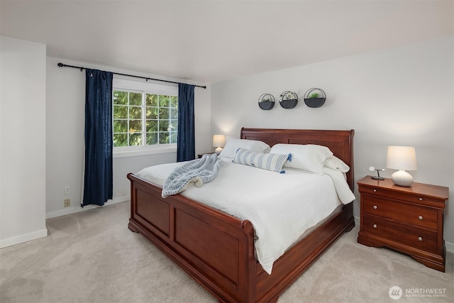 bedroom featuring baseboards and light carpet
