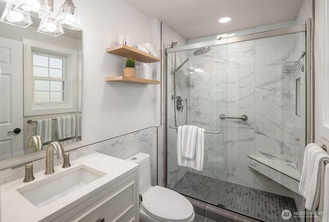 full bathroom featuring vanity, toilet, tile walls, recessed lighting, and a marble finish shower