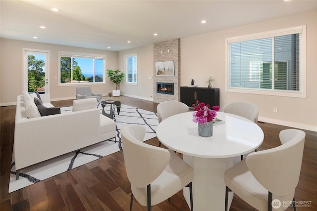 dining room featuring recessed lighting, dark wood finished floors, baseboards, and a tile fireplace
