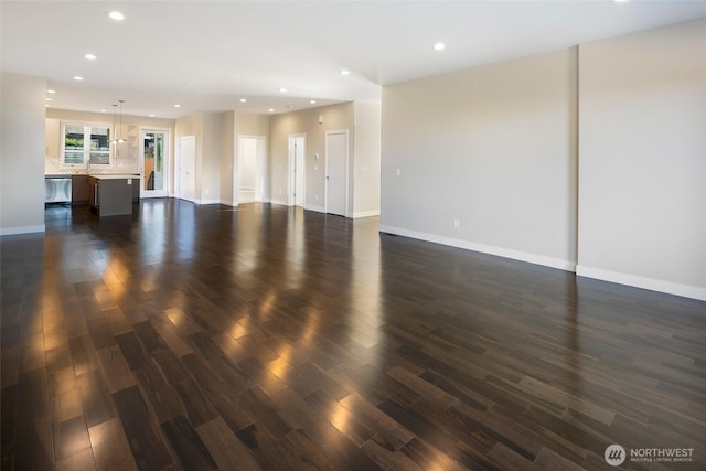 unfurnished living room featuring baseboards, recessed lighting, and dark wood-type flooring