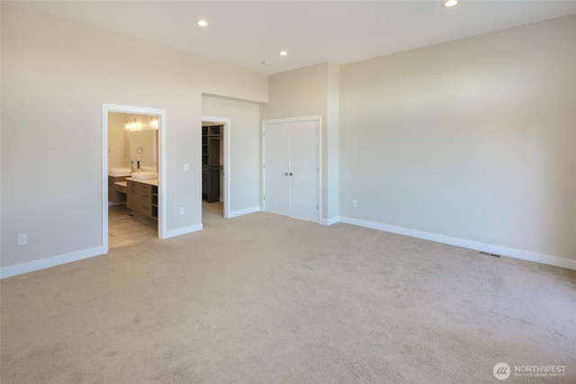 unfurnished bedroom with baseboards, light carpet, and recessed lighting