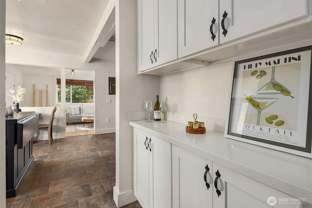 bar featuring stone finish flooring and baseboards