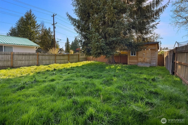 view of yard featuring a fenced backyard, an outbuilding, and a storage shed