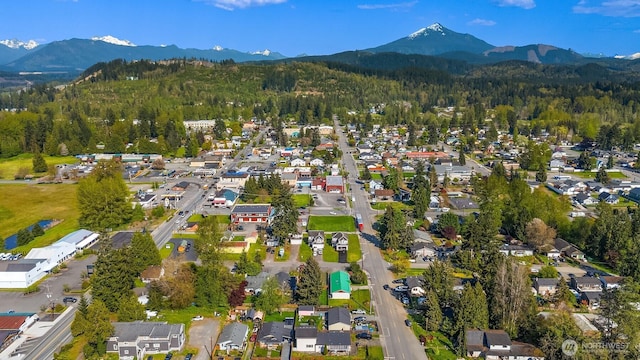 birds eye view of property featuring a wooded view, a mountain view, and a residential view
