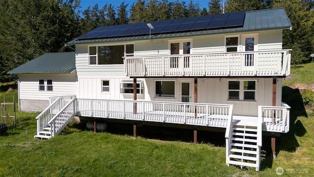 back of house with metal roof, roof mounted solar panels, stairway, and a balcony