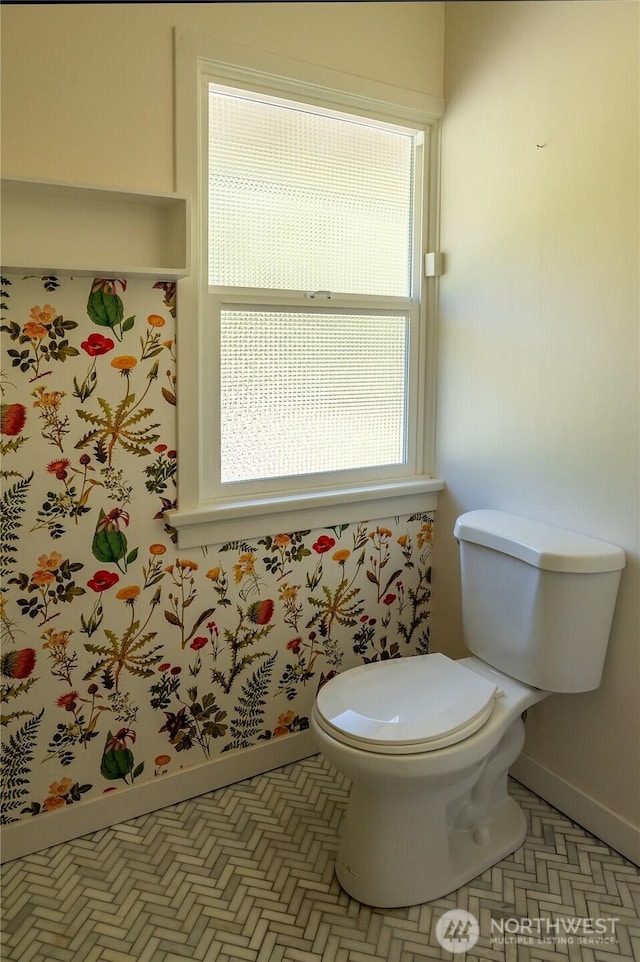 bathroom featuring baseboards and toilet