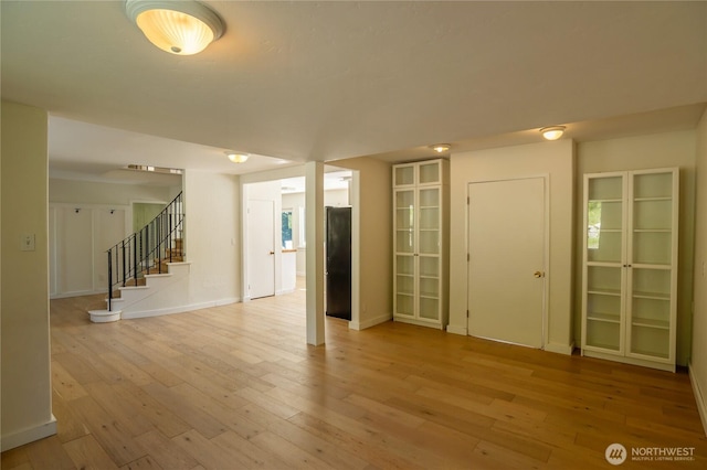 interior space with stairway, light wood finished floors, and baseboards