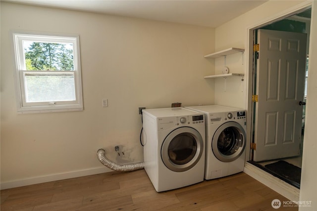 washroom featuring light wood-type flooring, baseboards, separate washer and dryer, and laundry area