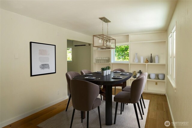 dining area with a wealth of natural light, wood finished floors, and baseboards