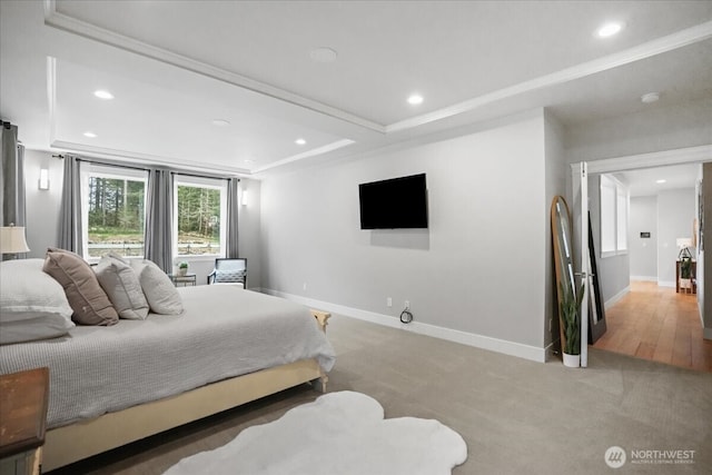 bedroom featuring recessed lighting, a raised ceiling, baseboards, and light colored carpet