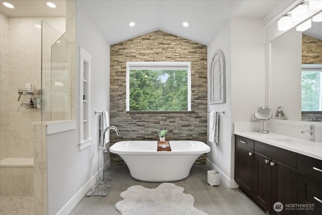 bathroom featuring a soaking tub, walk in shower, baseboards, and vaulted ceiling