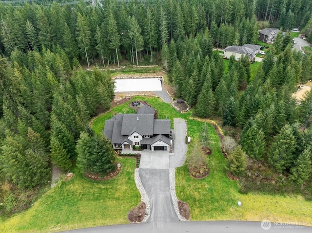 birds eye view of property featuring a forest view