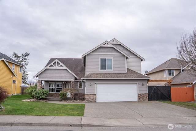 1509 Seahawk Dr, Ferndale, WA 98248 - craftsman-style house with fence, stone siding, a garage, a front yard, and concrete driveway