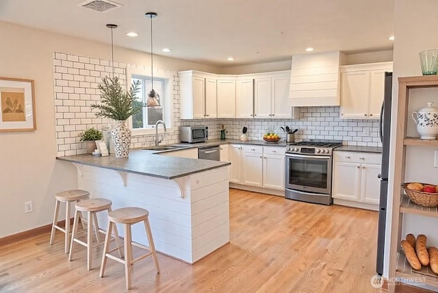 1509 Seahawk Dr, Ferndale, WA 98248 - kitchen with visible vents, appliances with stainless steel finishes, a sink, premium range hood, and a peninsula