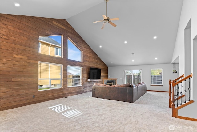 1509 Seahawk Dr, Ferndale, WA 98248 - carpeted living area with a ceiling fan, a fireplace, high vaulted ceiling, wooden walls, and recessed lighting