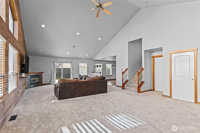 1509 Seahawk Dr, Ferndale, WA 98248 - carpeted living area with a fireplace, high vaulted ceiling, a ceiling fan, baseboards, and visible vents