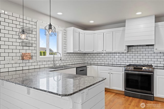 1509 Seahawk Dr, Ferndale, WA 98248 - kitchen with a peninsula, gas range, white cabinets, custom range hood, and a sink