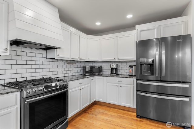 1509 Seahawk Dr, Ferndale, WA 98248 - kitchen featuring dark stone counters, stainless steel appliances, white cabinets, and custom exhaust hood