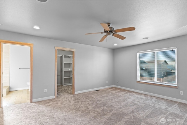 1509 Seahawk Dr, Ferndale, WA 98248 - unfurnished bedroom featuring connected bathroom, a walk in closet, carpet floors, recessed lighting, and baseboards
