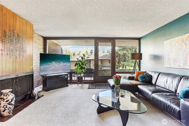 living room featuring wooden walls, a textured ceiling, and carpet