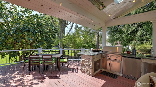 wooden deck with outdoor dining area, a sink, an outdoor kitchen, and grilling area