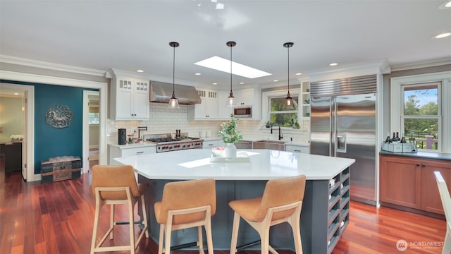 kitchen featuring appliances with stainless steel finishes, a skylight, tasteful backsplash, and a sink