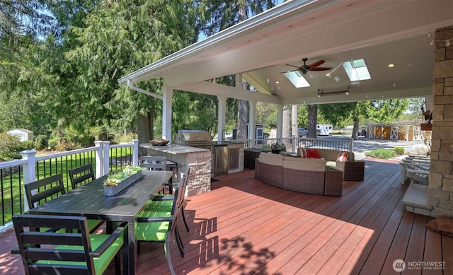 deck featuring an outdoor kitchen, ceiling fan, outdoor dining space, and an outdoor hangout area