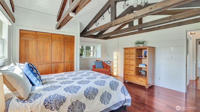 bedroom with dark wood finished floors, lofted ceiling with beams, a closet, and wood ceiling
