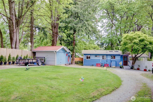 view of yard featuring entry steps, fence, an outbuilding, and a storage shed