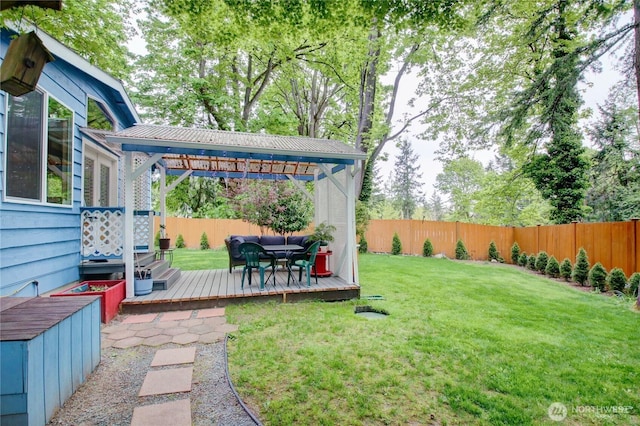 view of yard featuring a gazebo, a wooden deck, and a fenced backyard