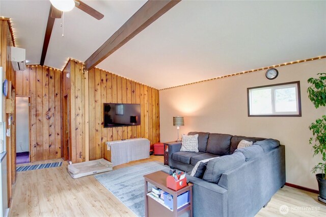 living room featuring wooden walls, ceiling fan, a wall unit AC, vaulted ceiling with beams, and wood finished floors