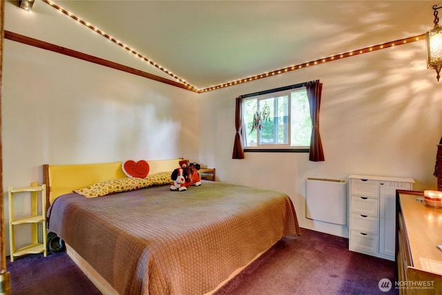 bedroom featuring radiator, vaulted ceiling, and dark carpet