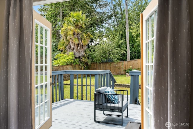 doorway featuring view of wooded area and wooden walls