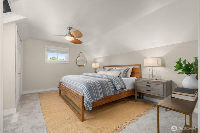 carpeted bedroom with a ceiling fan, lofted ceiling, and baseboards
