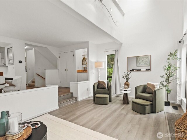 living room with baseboards, stairs, and wood finished floors