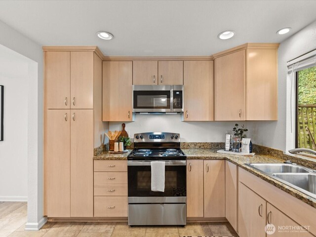 kitchen featuring a sink, light brown cabinets, and stainless steel appliances