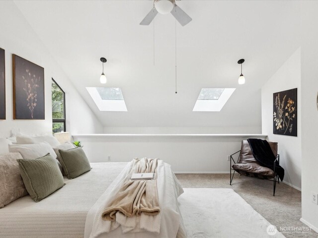 carpeted bedroom featuring baseboards, ceiling fan, and lofted ceiling with skylight