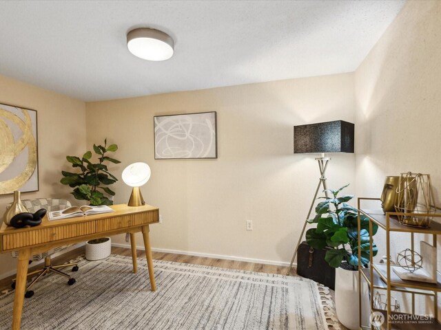 home office with baseboards and wood finished floors