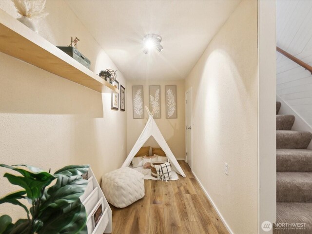 recreation room featuring baseboards and wood finished floors