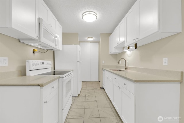 kitchen featuring marble finish floor, white appliances, light countertops, white cabinets, and a sink