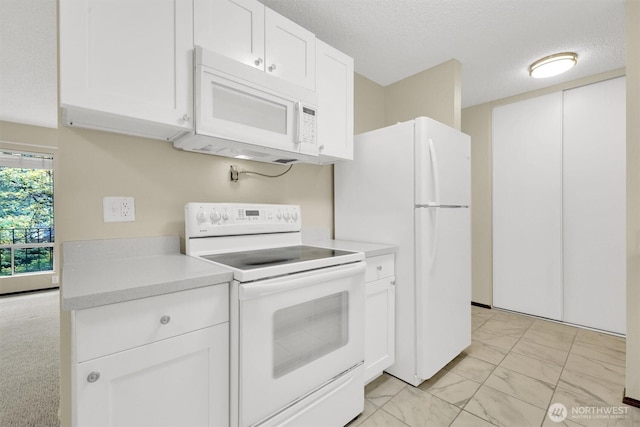 kitchen with light countertops, marble finish floor, white cabinets, and white appliances