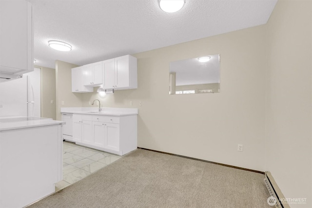 kitchen featuring white appliances, a textured ceiling, a baseboard heating unit, and a sink