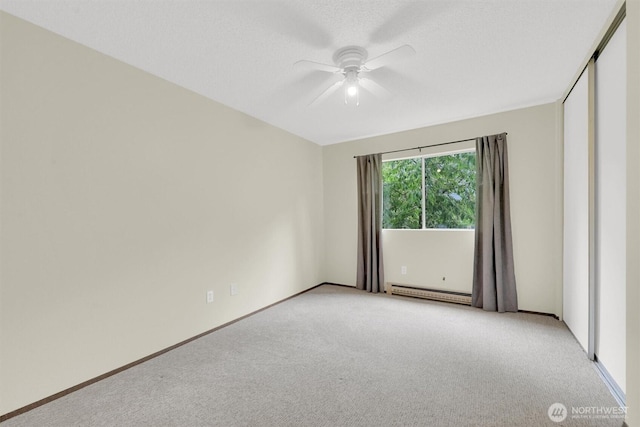 empty room featuring baseboards, a baseboard radiator, ceiling fan, and light colored carpet