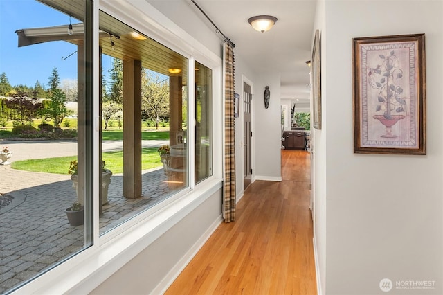 corridor featuring wood finished floors and baseboards